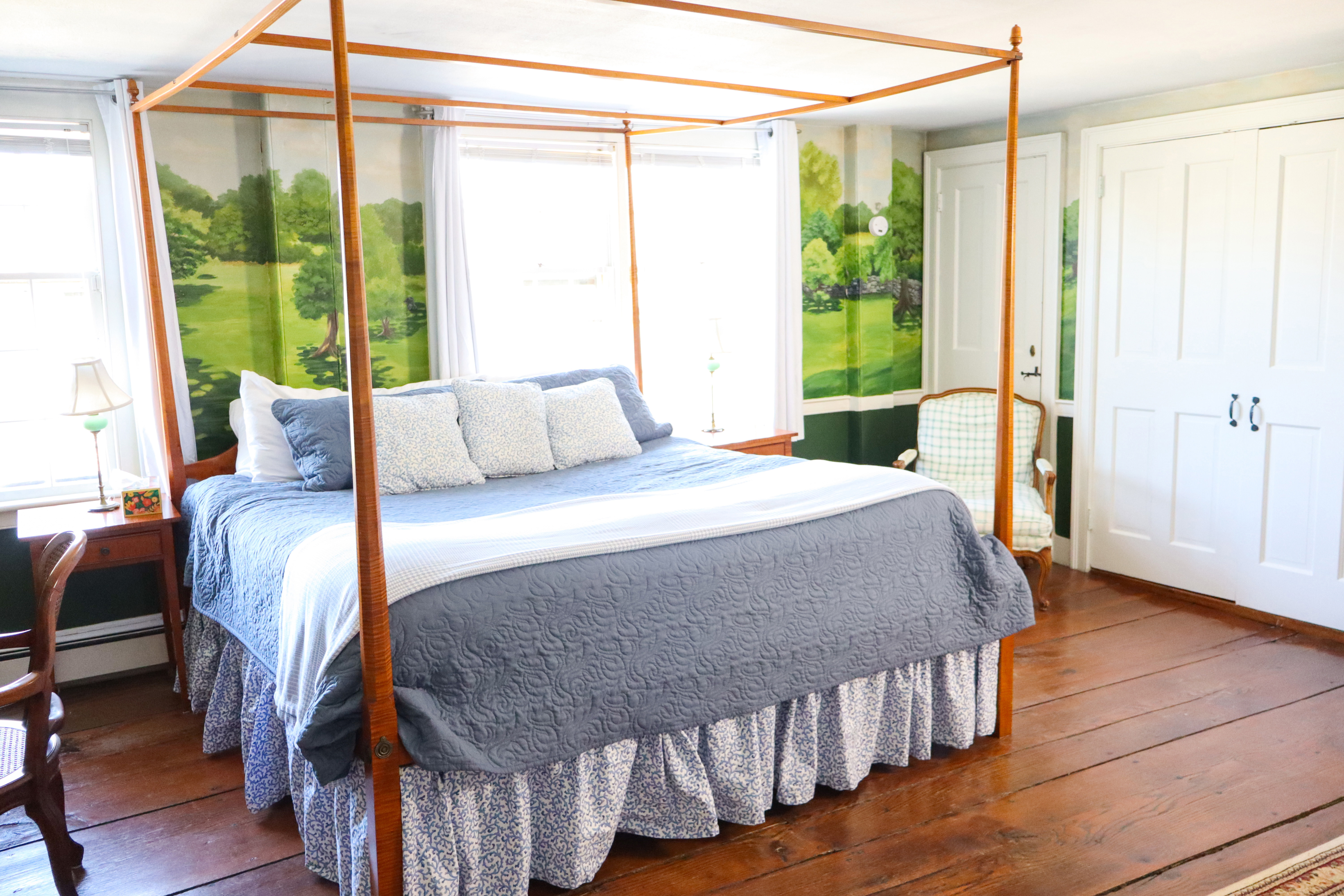 A romantic bedroom scene with mural and poster bed