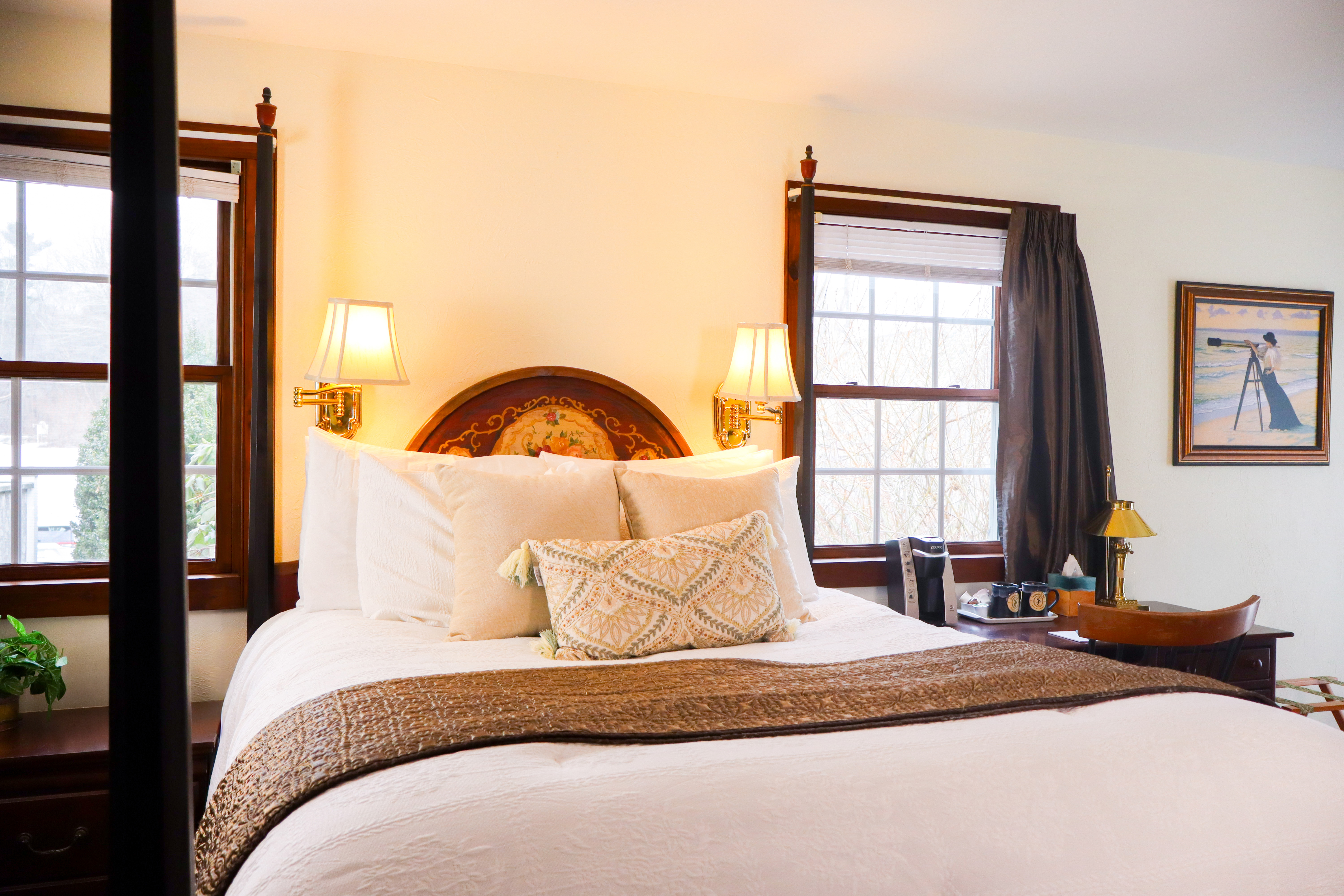 A well-lit bathroom featuring a glass-enclosed walk-in shower with a robe hanging nearby, and a vanity area with a mirror and stool.