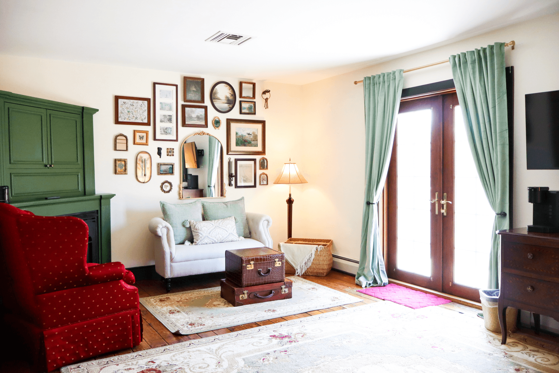 A classic bathroom vanity featuring a dark wood cabinet, a countertop sink, a gold-framed oval mirror, and striped wallpaper.