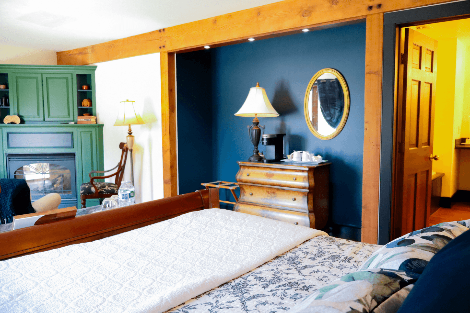 A charming outdoor deck with yellow siding, a small bistro table for two with wine glasses, and a view of surrounding greenery.