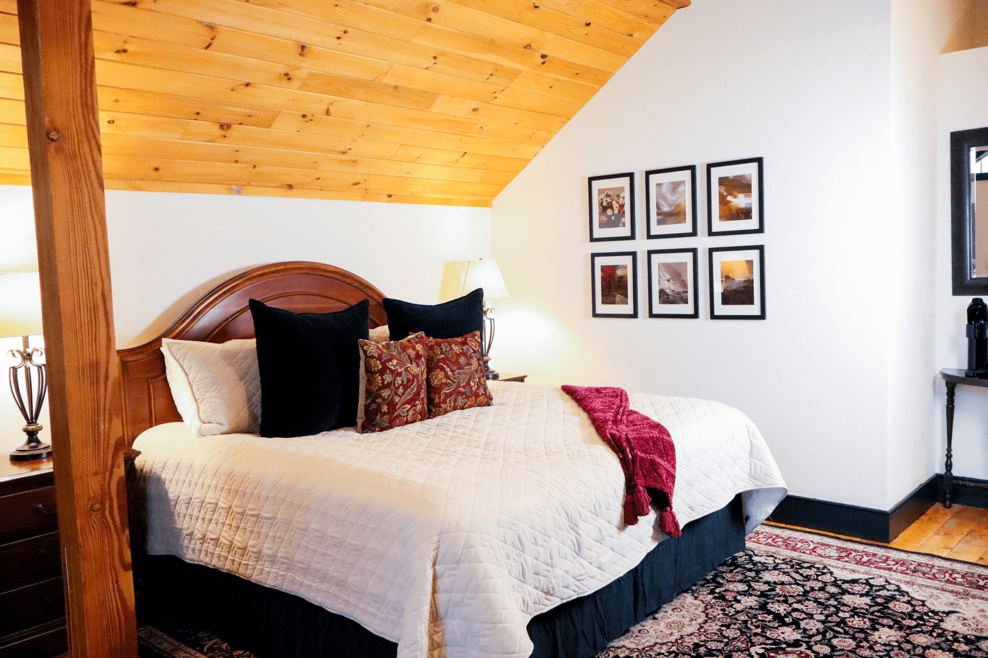 A bright, spacious bathroom with a wood-planked ceiling, a dark wood vanity, and an ornate gold-framed mirror.