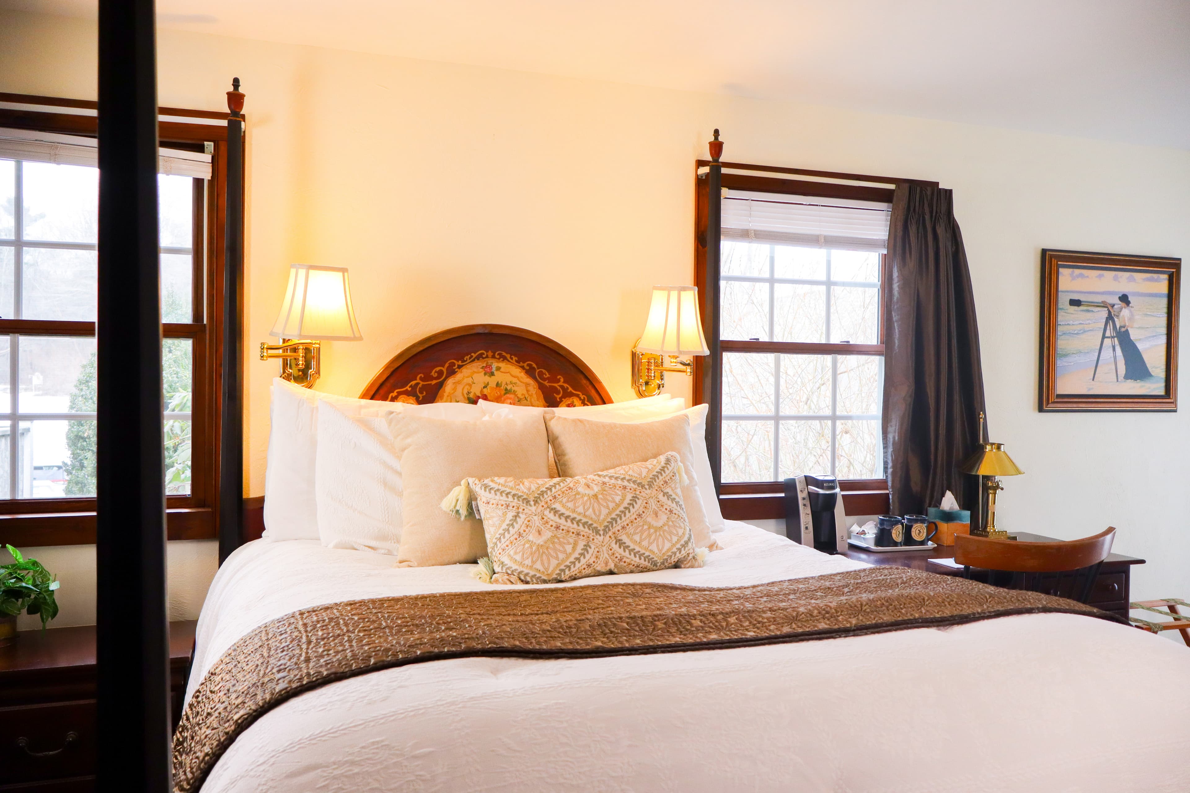 A well-lit bathroom featuring a glass-enclosed walk-in shower with a robe hanging nearby, and a vanity area with a mirror and stool.