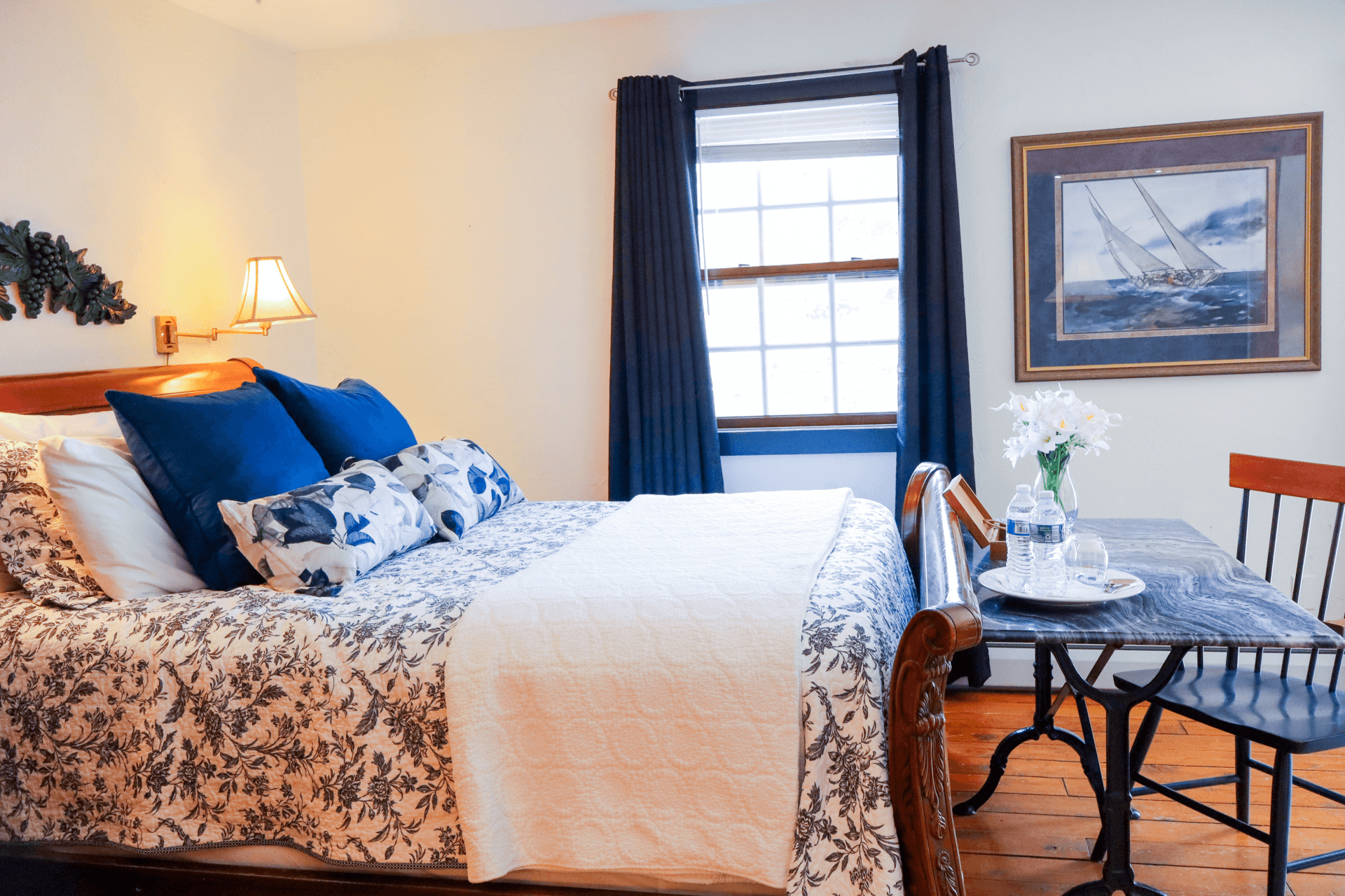 A romantic setting with a large jetted tub, two glasses of red wine, fresh flowers, and soft towels.