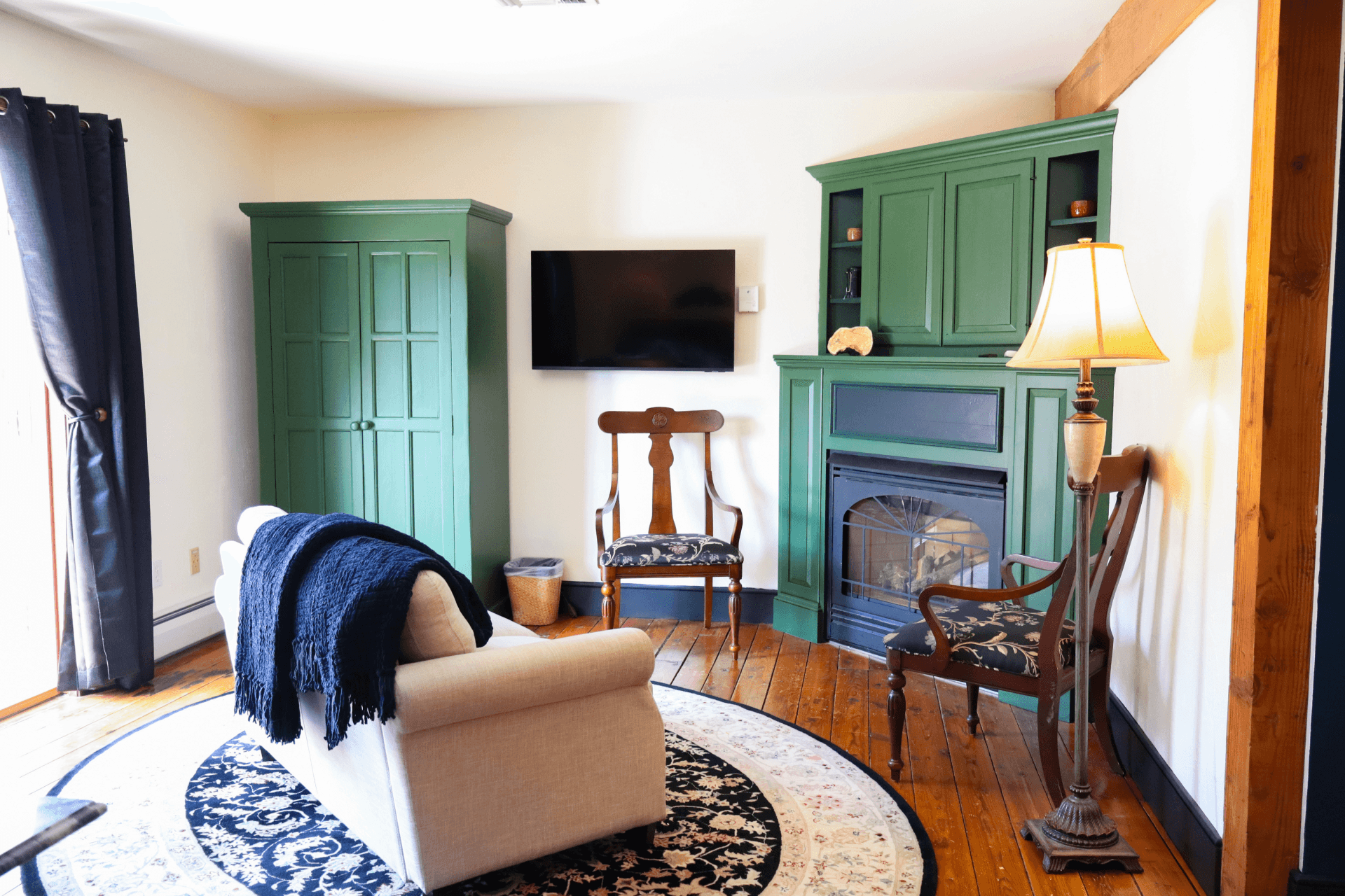 bathroom, showing a glass-enclosed walk-in shower and a peek into a bedroom with warm, rich-colored bedding.