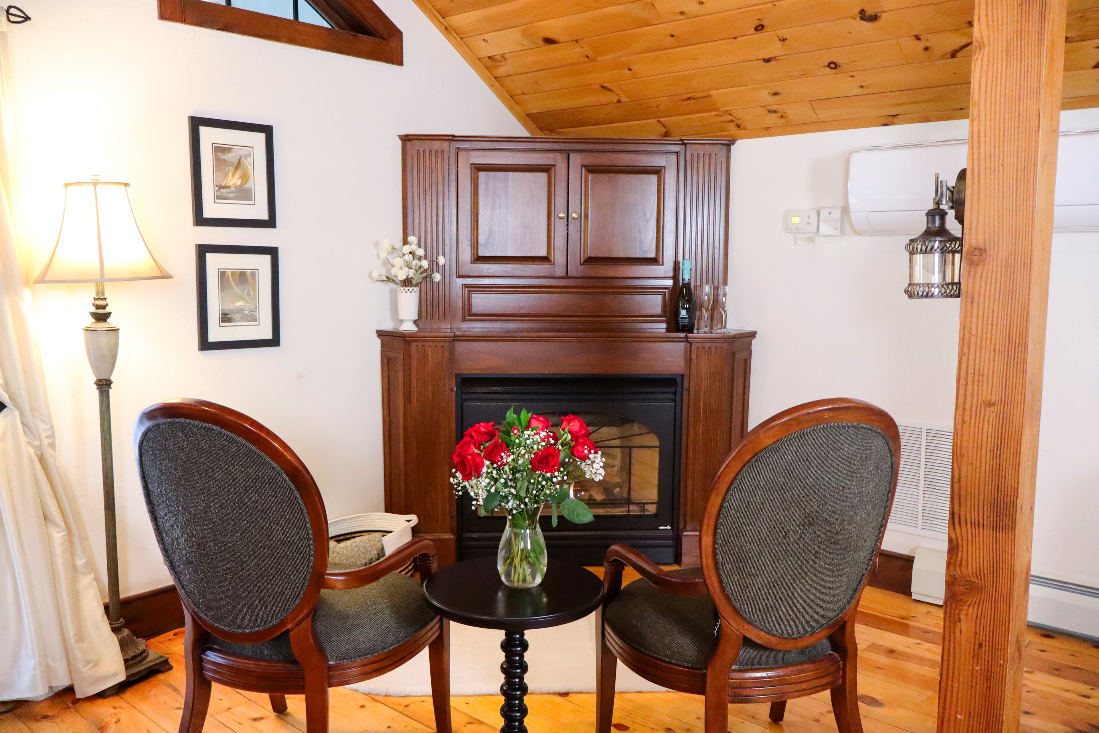 A warm, bright room with a dark wood writing desk and chair, polished wood floors, and French doors leading to an outdoor balcony.
