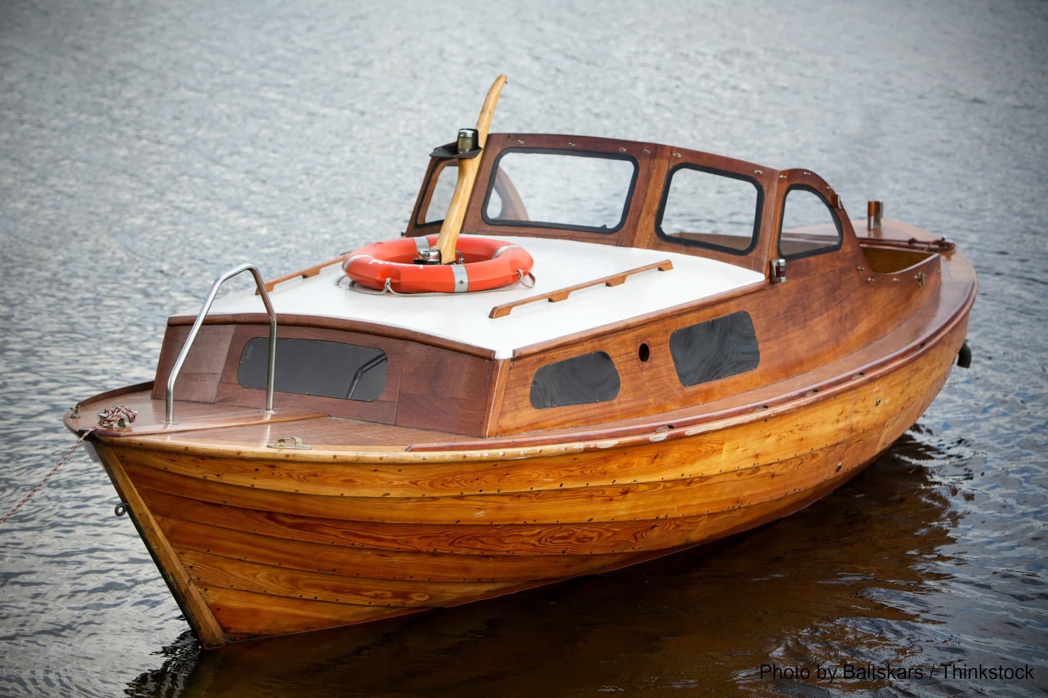 A vintage wooden boat floats on calm water.