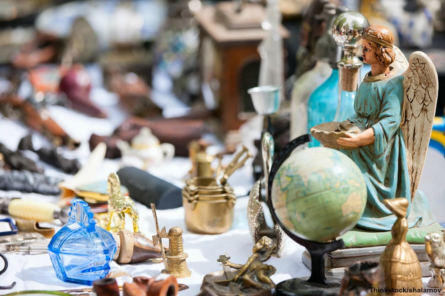 A collection of various antiques and knickknacks, including a globe and a figurine of an angel.