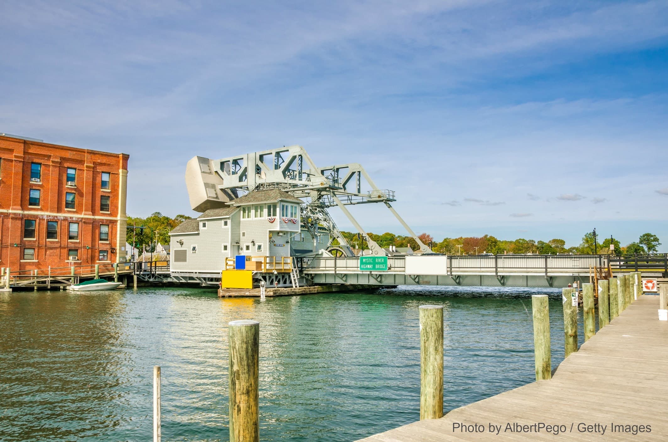 A drawbridge mechanism is visible over calm waters, with a brick building alongside. A drawbridge mechanism is visible over calm waters, with a brick building alongside.