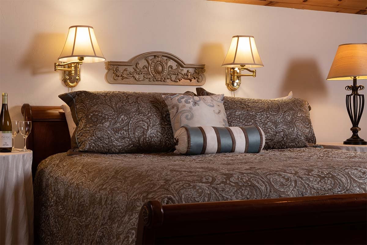 A beautifully styled bed with decorative pillows and soft lighting from bedside lamps.
