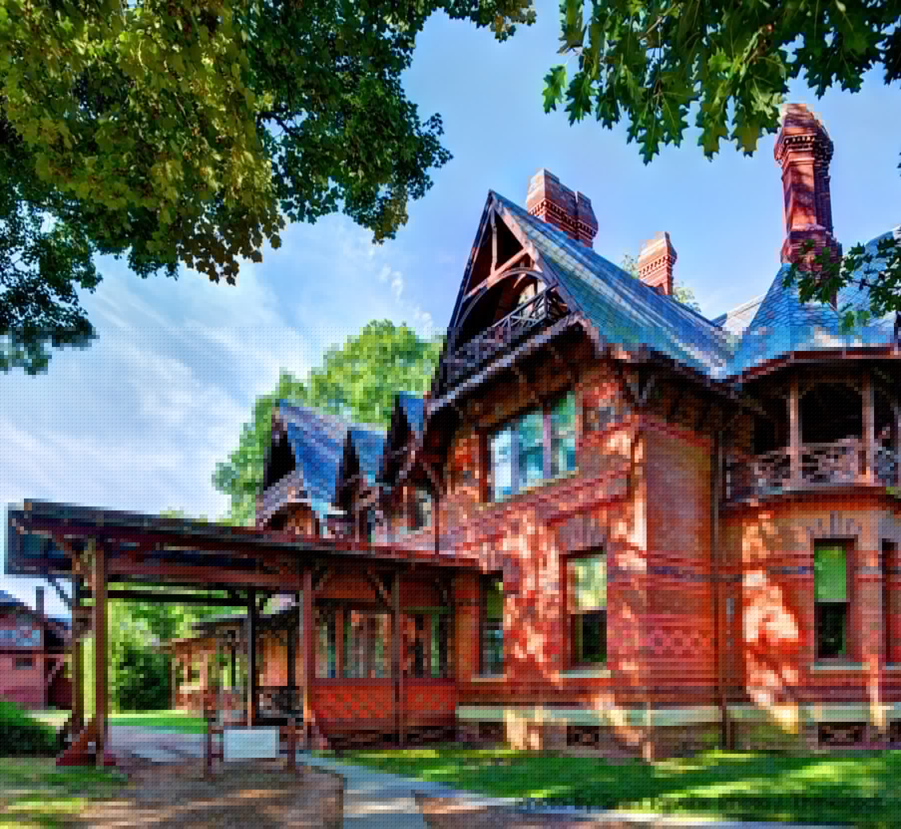 A picturesque brick home with intricate architectural details, surrounded by greenery.