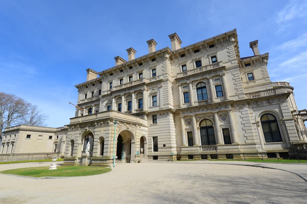 A grand, historic mansion with ornate architecture set against a clear blue sky.