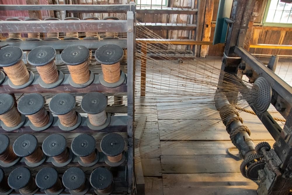 A bird's-eye view of a traditional weaving machine, showcasing spools of thread and intricate machinery.