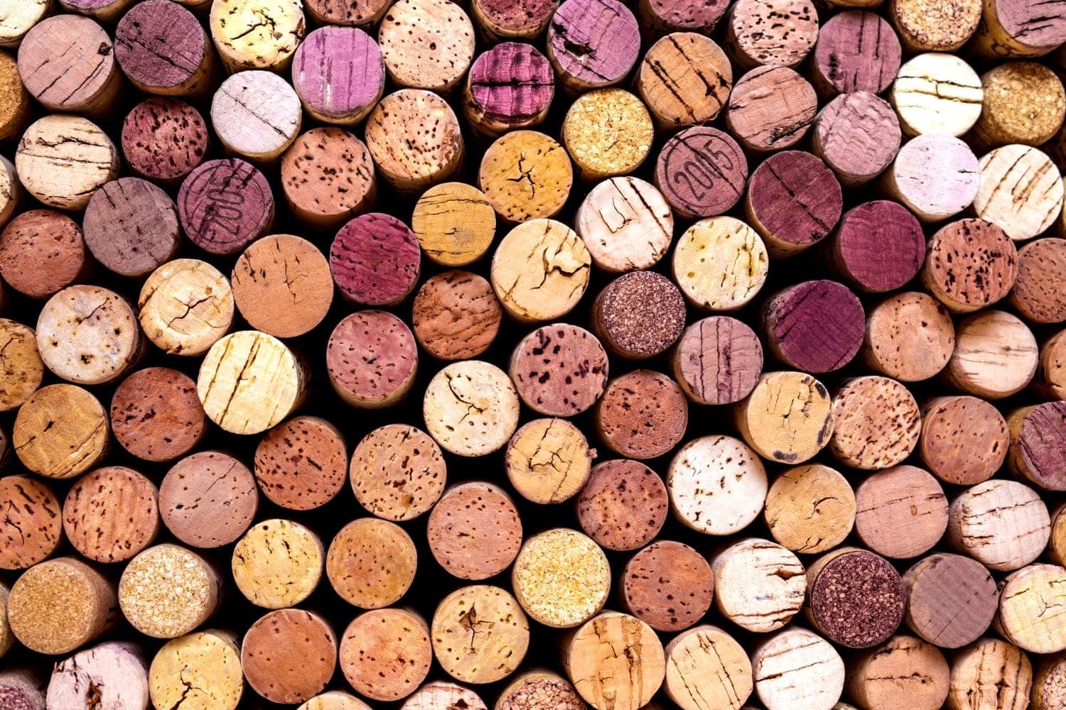 A close-up assortment of various wine corks arranged in a pattern.