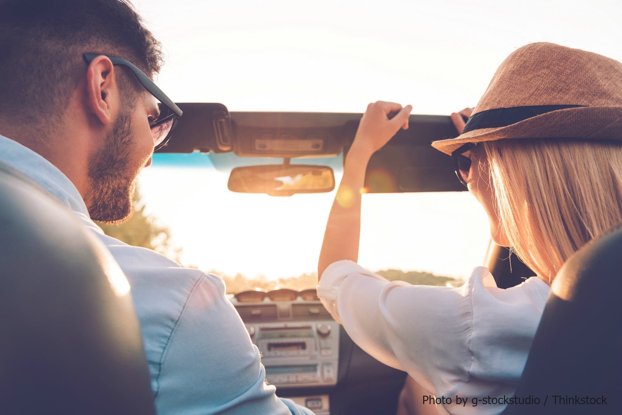 A couple enjoying a sunset drive in a convertible car. A couple enjoying a sunset drive in a convertible car.
