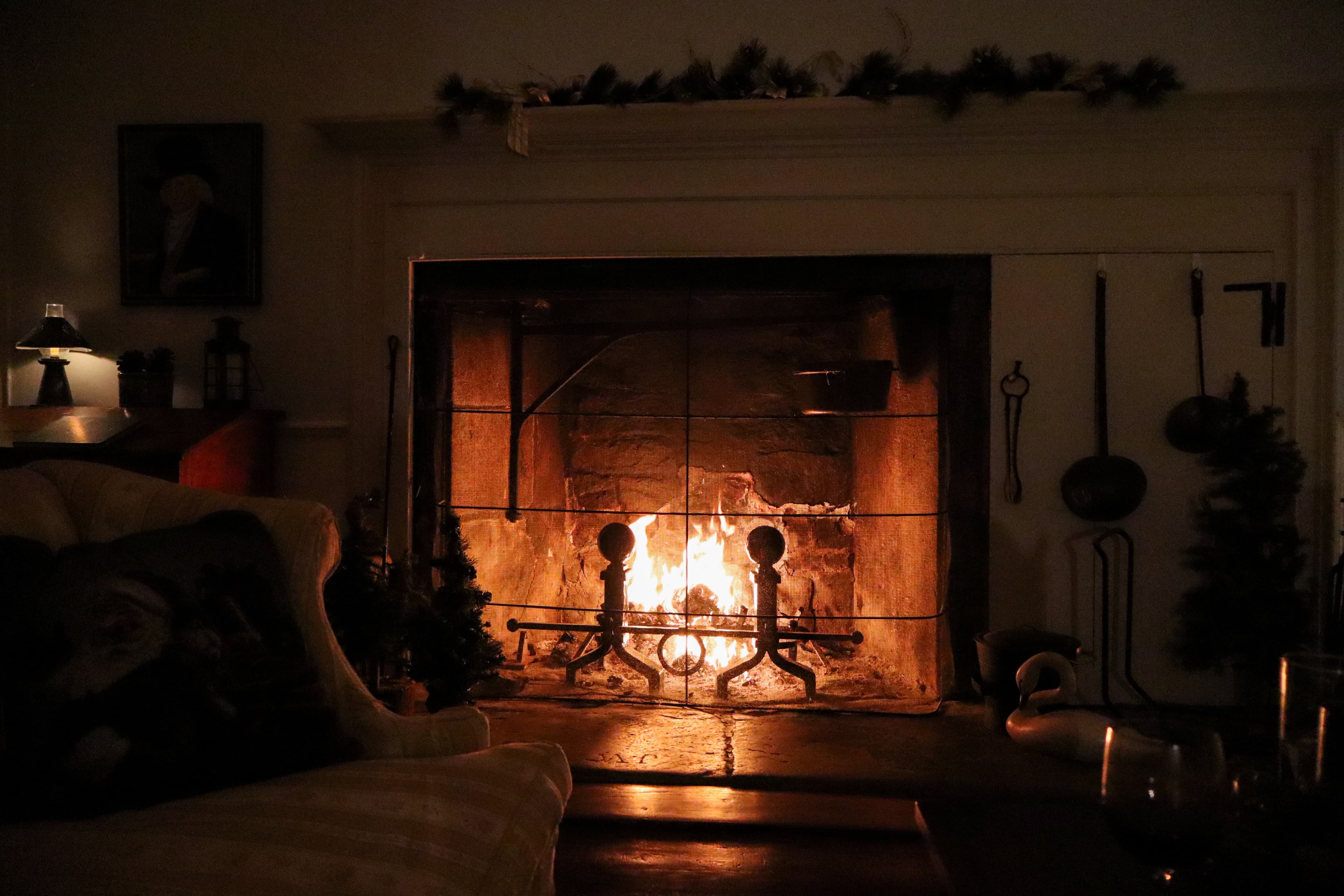 A cozy fireplace glowing warmly in a dimly lit room.