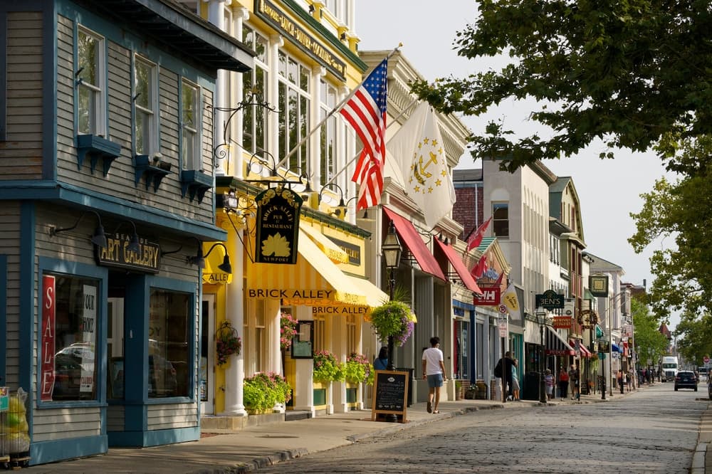 A charming street lined with shops and flags in a coastal town.
