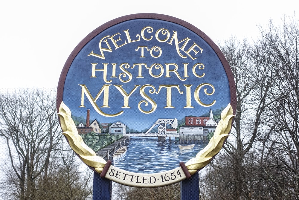 Sign welcoming visitors to Historic Mystic, featuring an artistic design and the year settled, 1654.