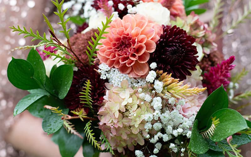 A vibrant bouquet featuring dahlias, hydrangeas, and lush greenery.