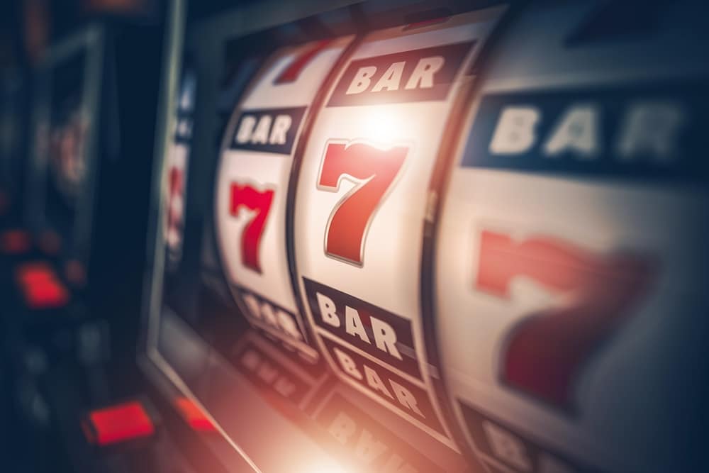 Close-up of slot machine reels showing the number seven and "BAR" symbols.