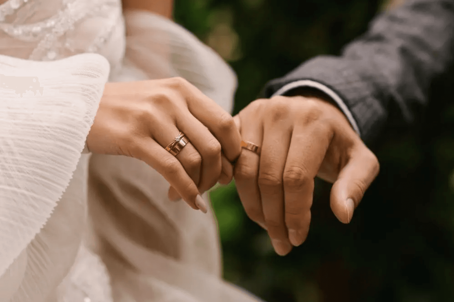A close-up of two hands adorned with wedding rings, gently holding each other. A close-up of two hands adorned with wedding rings, gently holding each other.