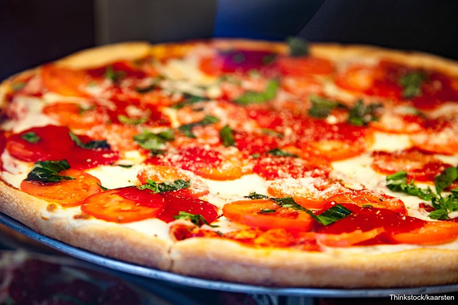 A close-up of a pizza topped with tomatoes, basil, and cheese.