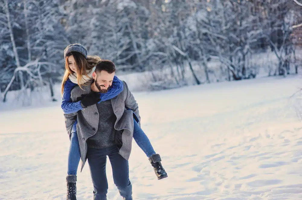 Things to do in New England--happy couple on a snowy walk 